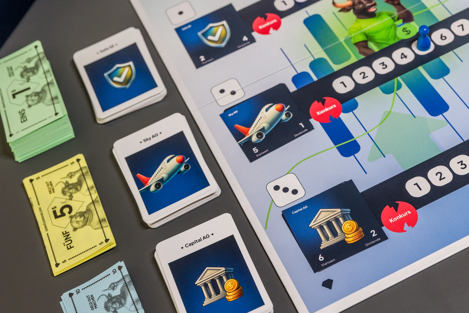 Vermögenshelden: Aktienkarten, Spielgeld und Spielbrett.
